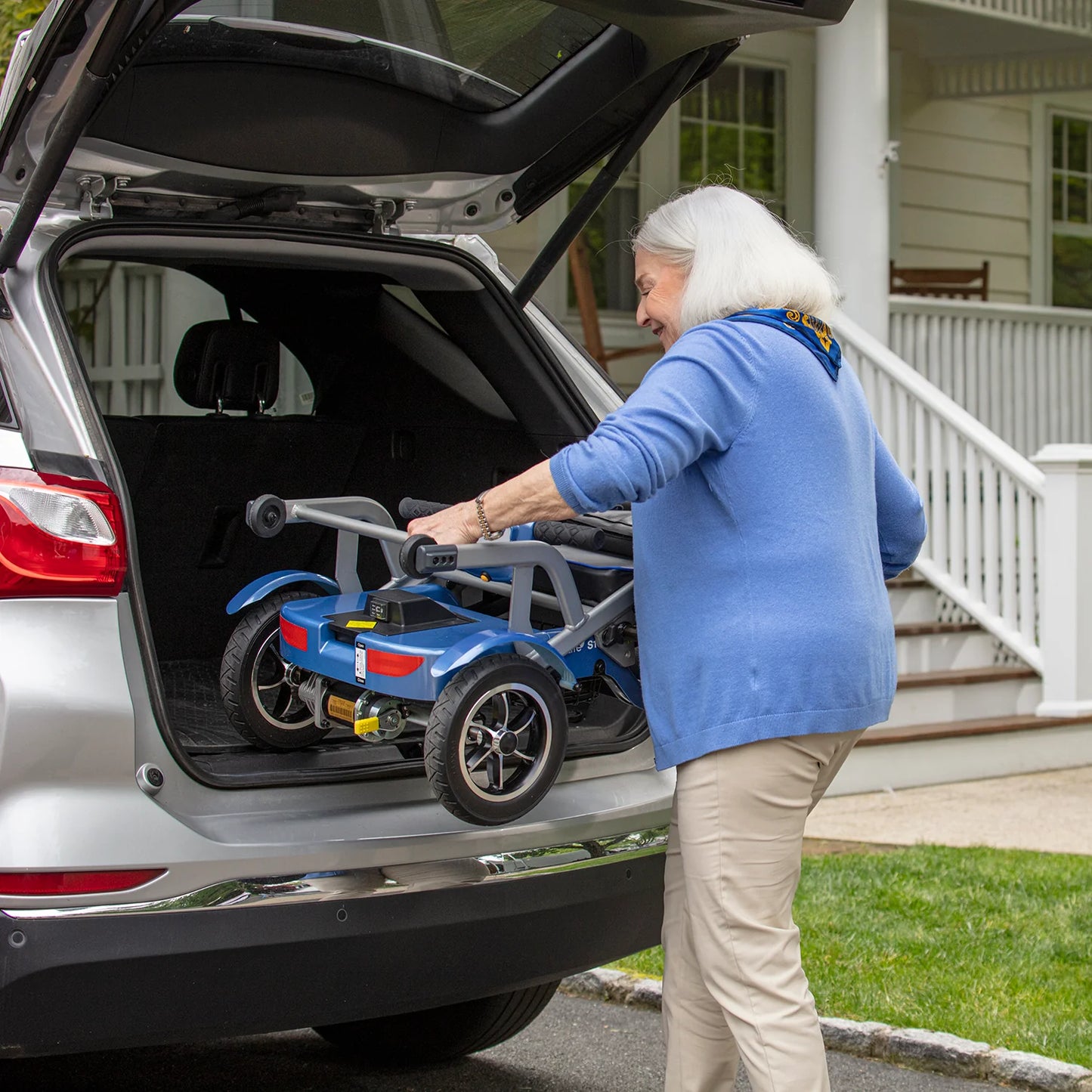 Senior loading the Journey So Lite Lightweight Folding Power Scooter into the trunk of her vehicle